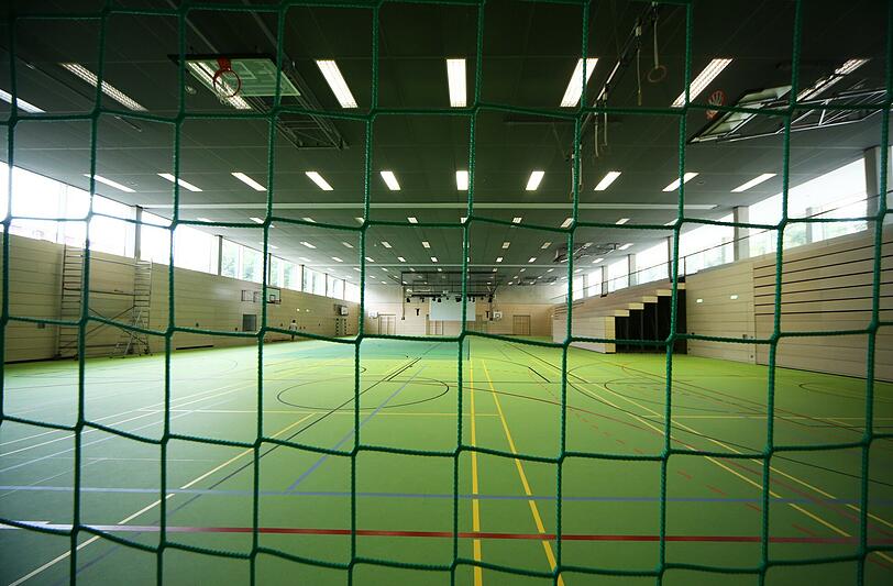 Die Turnhalle lässt sich mit Trennwänden in drei verschiedene Bereiche abteilen. An der Zuschauertribüne (rechts) fehlt noch das Geländer.