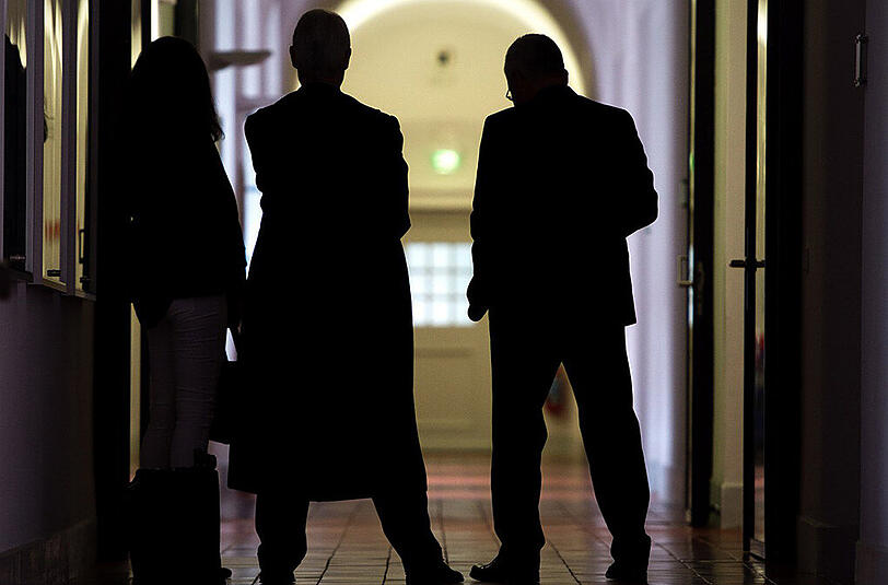 Der Ex-Agent (r.) mit Anwalt und Begleitung im Gerichtsflur.