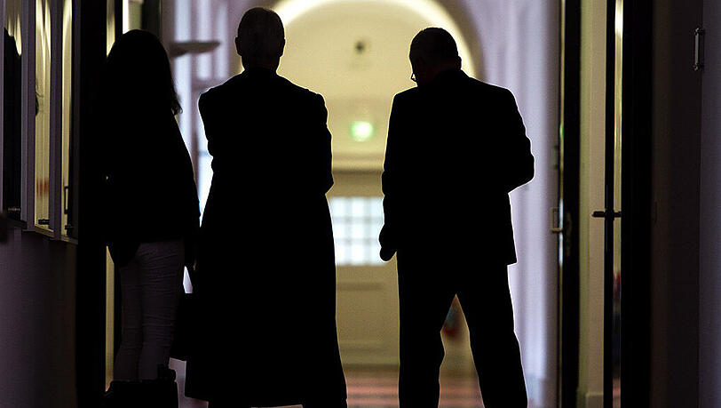 Der Ex-Agent (r.) mit Anwalt und Begleitung im Gerichtsflur. Der Ex-Agent (r.) mit Anwalt und Begleitung im Gerichtsflur.