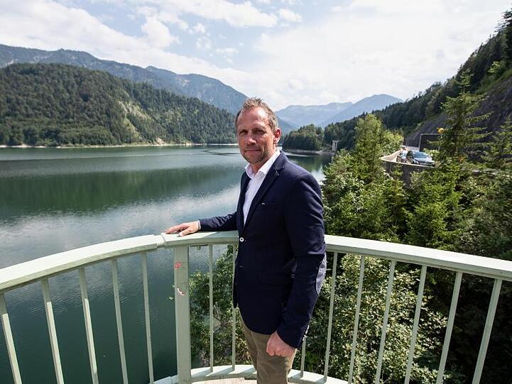 Thorsten Glauber, Umweltminister von Bayern, steht am Sylvensteinstausee. Foto: Matthias Balk/dpa