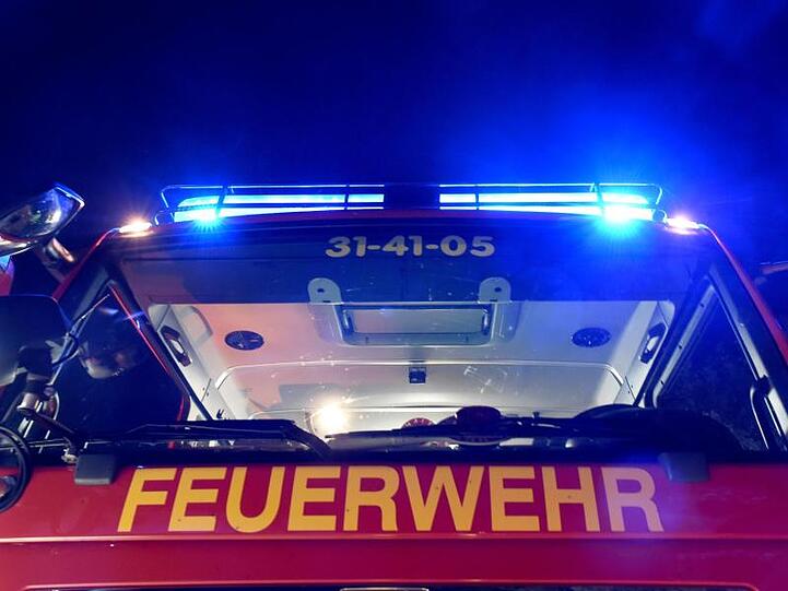 Ein Löschfahrzeug der Feuerwehr steht mit eingeschaltetem Blaulicht. Foto: picture alliance/Carsten Rehder/dpa/Archiv/Symbolbild