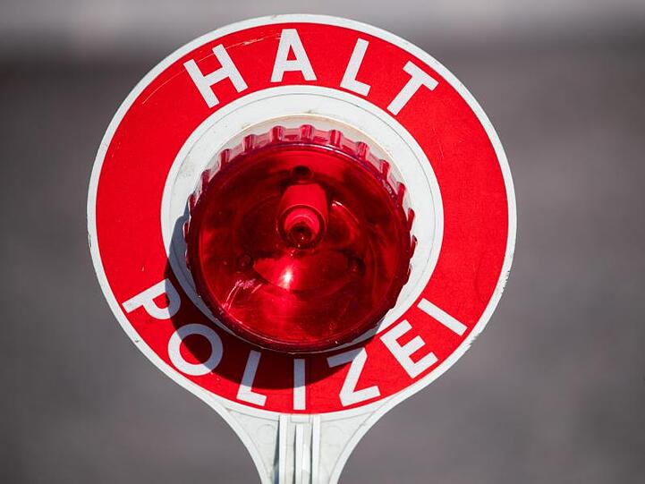 "Halt Polizei" steht auf einer Polizeikelle. Foto: Daniel Karmann/Archivbild