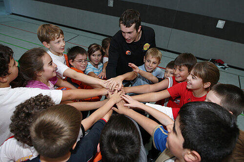 Bastian Doreth vom Verein &bdquo;Franken-Hexer&ldquo; mit dem begeisterten Basketball-Nachwuchs der Helene von Forster Schule.