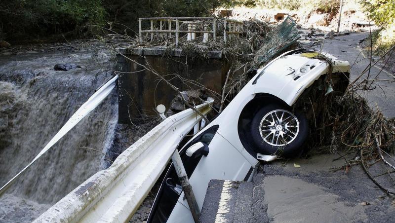 Ein Auto hängt an einer eingestürzten Straße über einem Fluss fest. Ein Auto hängt an einer eingestürzten Straße über einem Fluss fest.