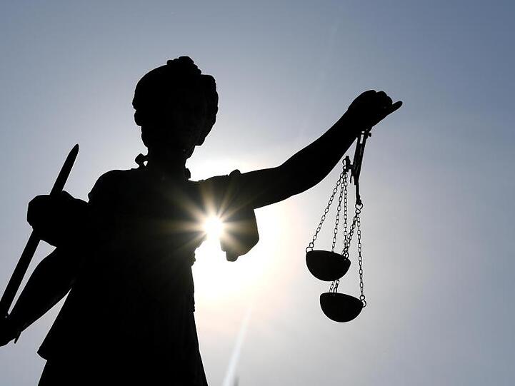 Die Statue der Justitia steht mit einer Waage und einem Schwert in der Hand. Foto: Arne Dedert/dpa/Archivbild