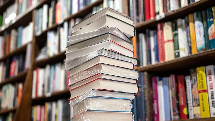 Ein Bücherstapel liegt in einer Buchhandlung auf dem Tisch.