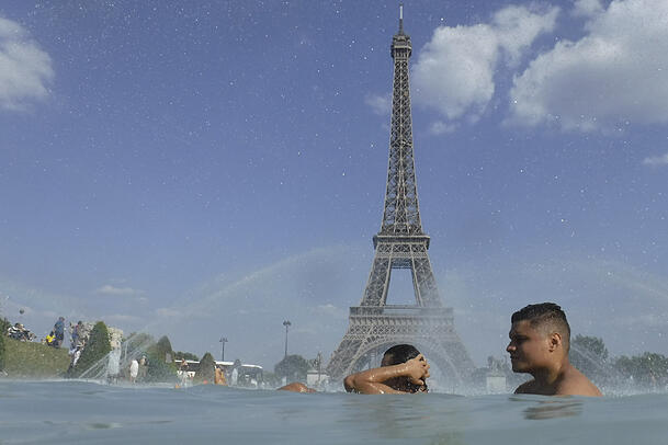 Menschen kühlen sich im Brunnen des Jardin du Trocadéro in Paris ab. Menschen kühlen sich im Brunnen des Jardin du Trocadéro in Paris ab.