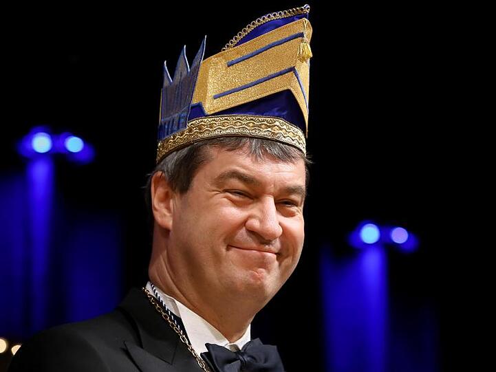 Ministerpräsident Markus Söder (CSU) trägt eine Narrenkappe und lächelt. Foto: Daniel Karmann/dpa/Archivbild