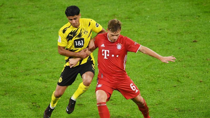 Dortmunds Mahmoud Dahoud (l) versucht Bayerns Joshua Kimmich den Ball abzunehmen.