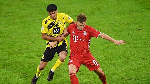 Dortmunds Mahmoud Dahoud (l) versucht Bayerns Joshua Kimmich den Ball abzunehmen.