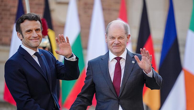 Frankreichs Präsident Emmanuel Macron (l) empfängt Bundeskanzler Olaf Scholz (SPD) am Schloss in Versailles.
