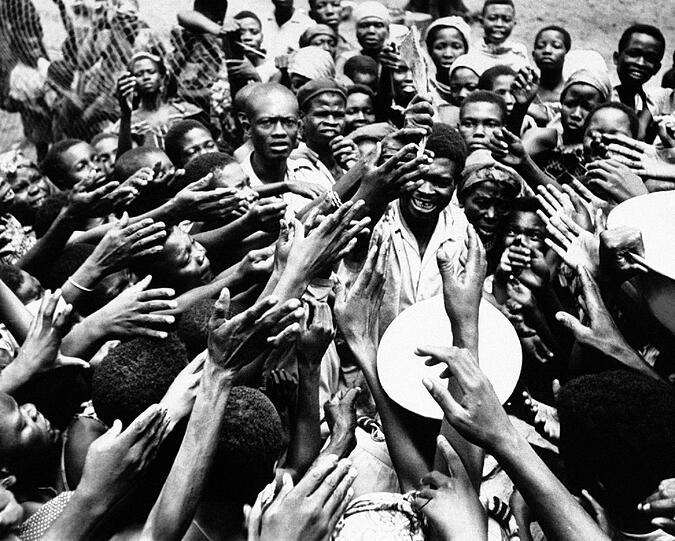 Auch in anderen Krisengebieten arbeitete der Kriegsfotograf Faas. 1961 entstand bei einem Krankenhaus in Miabi im Kongo dieses Bild: Zahlreiche Hände greifen gierig in die Luft - alle wollen etwas von den schmalen Rationen getrockneten Fischs und vom Palmöl abbekommen, die ein kongolesischer Beamter verteilt.