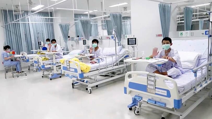 Einige der geretteten Jungen winken von ihrem Krankenbett aus dem Chiang Rai Prachanukroh Hospital.