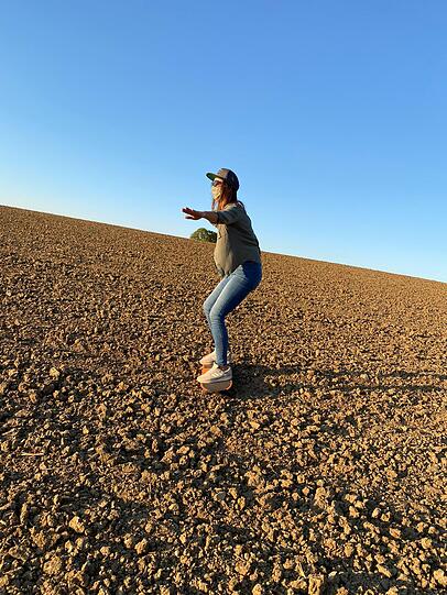 Natalie Moll beim Sandboarding auf einem Acker.