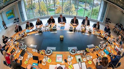 Mitglieder des bayerischen Kabinetts sitzen in der bayerischen Staatskanzlei auf ihren Plätzen. Foto: Peter Kneffel/dpa/Archivbild