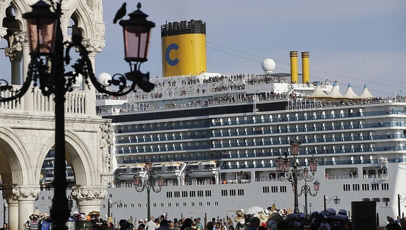 Das Kreuzfahrtschiff "Costa Deliziosa" fährt am Markusplatz vorbei, auf dem zahlreiche Touristen unterwegs sind. Das Kreuzfahrtschiff "Costa Deliziosa" fährt am Markusplatz vorbei, auf dem zahlreiche Touristen unterwegs sind.
