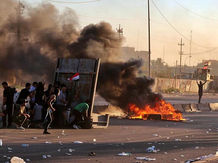 Regierungsfeindliche Demonstranten haben während einer Demonstration in Bagdad Feuer gelegt und eine Straße blockiert.