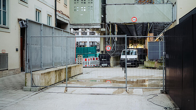 Durch die wenigen Gucklöcher, die am Bauzaun noch geblieben sind, ist nicht viel zu erspähen, außer einem Kleinbus, Containern, Absperrgittern und Baumaterial. Durch die wenigen Gucklöcher, die am Bauzaun noch geblieben sind, ist nicht viel zu erspähen, außer einem Kleinbus, Containern, Absperrgittern und Baumaterial.