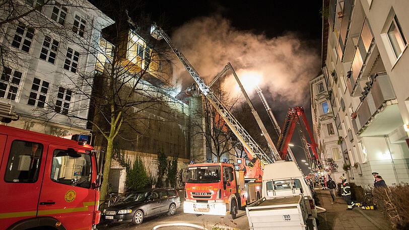 Feuerwehrleute löschen am 17.12.2017 in Hamburg ein brennendes Holz-Penthaus, das auf einem Bunker aus dem Zweiten Weltkrieg steht. Mit rund 100 Einsatzkräften war die Feuerwehr vor Ort, um den Brand zu löschen und an den Brandherd zu gelangen, wie ein Feuerwehr-Sprecher berichtete. Verletzte habe es nicht gegeben.