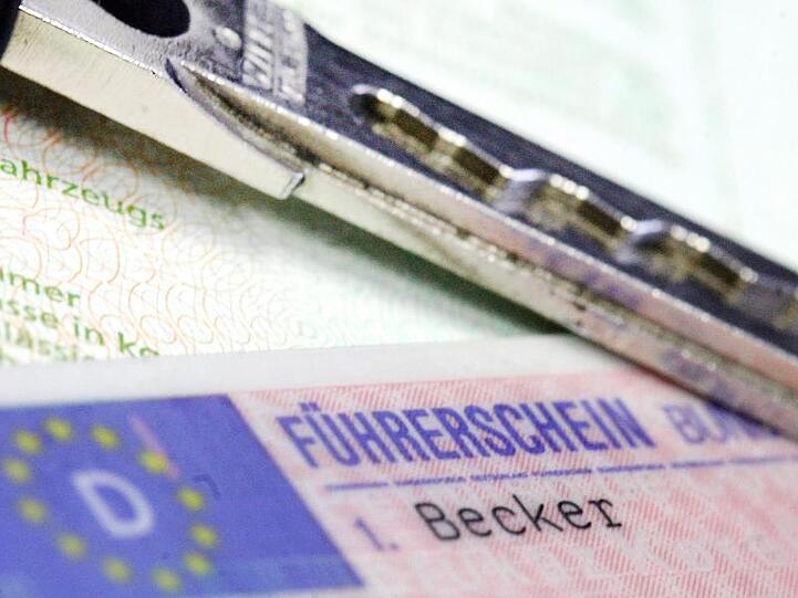 Ein Führerschein und ein Autoschlüssel liegen auf einem Fahrzeugschein. Foto: Marius Becker/dpa