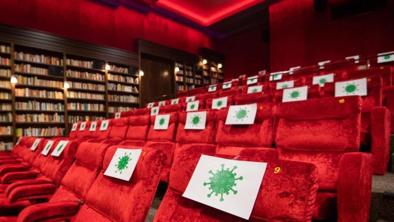 Einzelne Sitzplätze in einem Kinosaal sind mit Zetteln mit aufgedrucktem angedeuteten Virus-Symbol abgesperrt, damit Kino-Besucher einen Abstand von 1,5 Meter zueinander einhalten können.