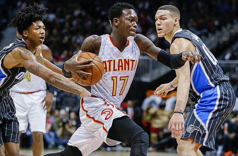 Dennis Schröder von den Atlanta Hawks (Mitte) im Duell mit Aaron Gordon (rechts) von den Orlando Magic.