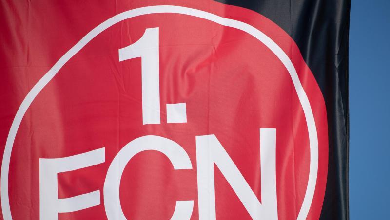 Eine Vereinsfahne mit dem Logo des 1. FC Nürnberg weht im Wind. Foto: Daniel Karmann/dpa/Symbolbild Eine Vereinsfahne mit dem Logo des 1. FC Nürnberg weht im Wind. Foto: Daniel Karmann/dpa/Symbolbild