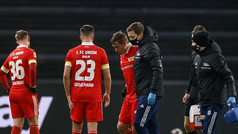 Unions Max Kruse (M) wird verletzt zur Seitenlinie geführt.