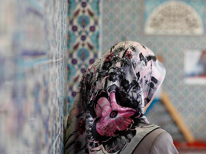 Eine Frau trägt ein buntes, mit Blumen verziertes Kopftuch. Foto: Axel Heimken/Archiv