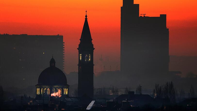 St. Ursula im ersten Morgenlicht: Kuppel und Campanile funkeln, das Hypo-Hochhaus rechts liegt noch im Dunkeln - eingefangen vom Olympiaberg aus.