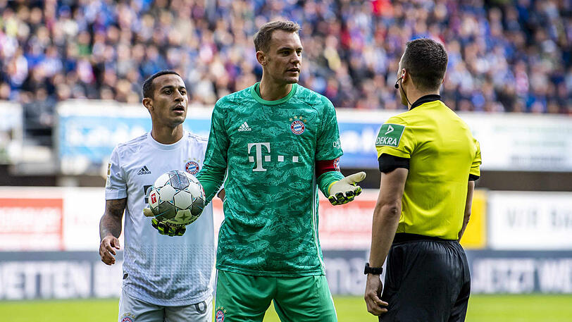 Thiago (l.) und Manuel Neuer (m.) im Gespräch mit Schiedsrichter Felix Zwayer.