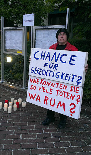 Der erste Demonstrant Timo Tasche (32) mit Schild und elf Kerzen auf dem Platz vor dem Justizzentrum. Der Taxifahrer Stammt aus Marl in NRW und will den ganzen Tag bleiben. "Dann fahre ich wieder heim"