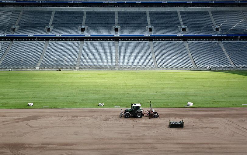 ... es wird aber lediglich ein neuer Rasen verlegt. Ein Traktor ebnet in der Allianz Arena in München den Boden bevor der neue Rasen drauf kann.