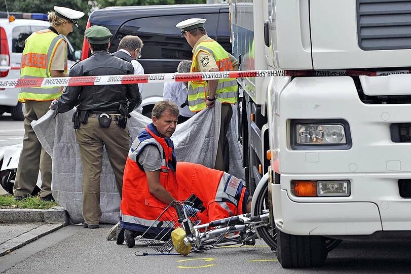 Tödlicher Radlunfall am Petuelring: Vorne klemmt das Fahrrad im Radkasten des Lkw, hinten verdecken Hilfskräfte die Stelle, an der die Frau (53) ums Leben kam.