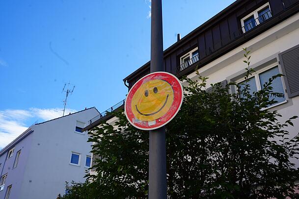Ziviler Ungehorsam auf andere Art (und auch verboten): Jemand hat das neue Halteverbotsschild mit einem Lach-Smiley überklebt.