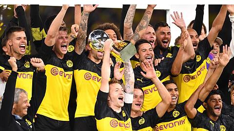 Dortmunds Marco Reus (M) bejubelt mit seinem Trainer Lucien Favre (l) und Mitspielern den Gewinn des Supercups 2019.