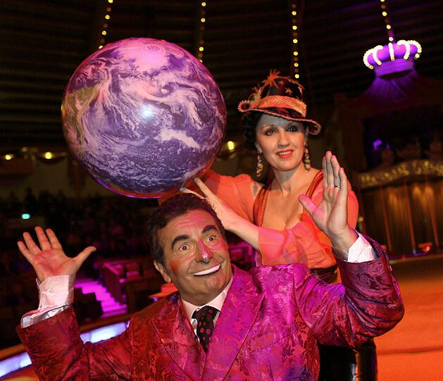 Angelika Zwerenz und Clown Francesco drehen an der Erdkugel.