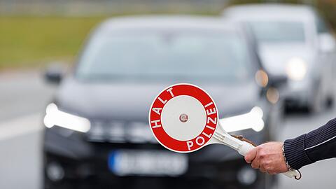 Ein Beamter der Bundespolizei stoppt bei der kontrolle des Einreiseverkehrs am deutsch-tschechischen Grenzübergang ein Auto.