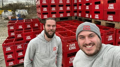 Rainer Pieknik (l.) und Simon Klur (r.) posieren vor den Kästen ihres Isarkindl-Biers. Ihr Bier ist aus einem Innovationswettbewerb der TU München im Jahr 2014 entstanden. Elf Jahre später haben die beiden die Produktion ihres Bieres eingestellt.