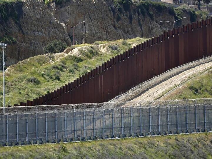 Blick auf die Grenzbefestigung zwischen den Vereinigten Staaten und Mexiko, die sich durch die Hügel zwischen San Diego und Tijuana schlängelt.