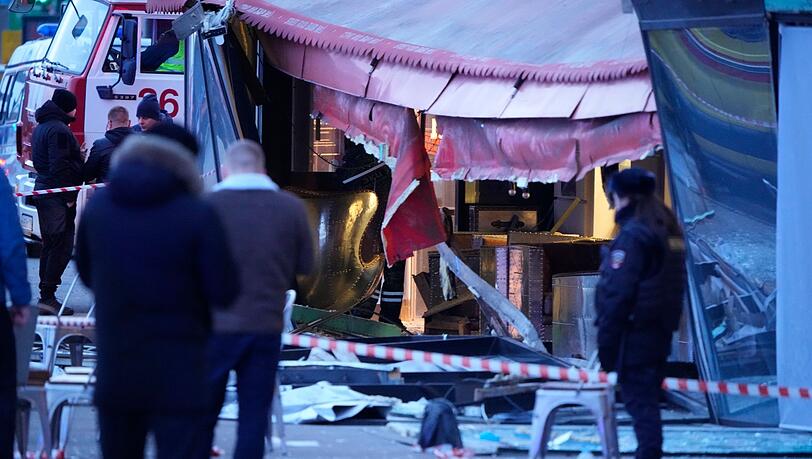 Russische Ermittler und Polizisten stehen nach der Explosion am Tatort in Sankt Petersburg.