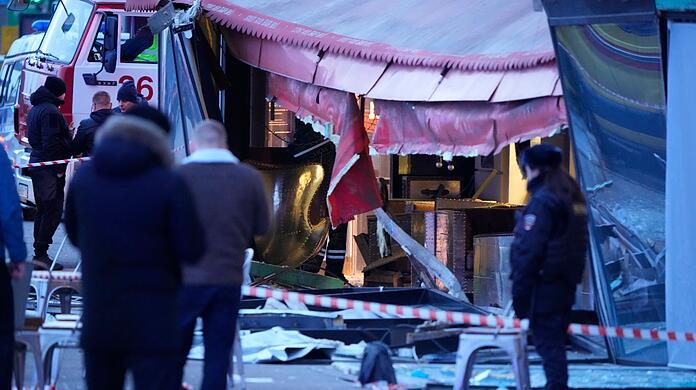 Russische Ermittler und Polizisten stehen nach der Explosion am Tatort in Sankt Petersburg.