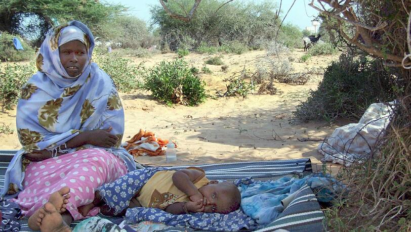 Eine Mutter in Somalia mit ihren beiden Kindern. Eine Mutter in Somalia mit ihren beiden Kindern.
