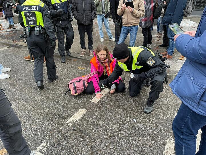 Trotz der Polizeipräsenz schaffte es eine dritte Aktivistin, sich auf der Straße festzukleben.