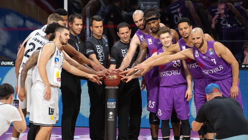 Vor dem Auftaktspiel stehen die Spieler und die Schiedsrichter um den Spielball auf einer Säule mit dem Text: "United Against Racism". Vor dem Auftaktspiel stehen die Spieler und die Schiedsrichter um den Spielball auf einer Säule mit dem Text: "United Against Racism".
