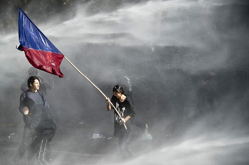 Studenten werden während Protesten gegen das Bildungssystem in Santiago mit Wasserwerfern beschossen.