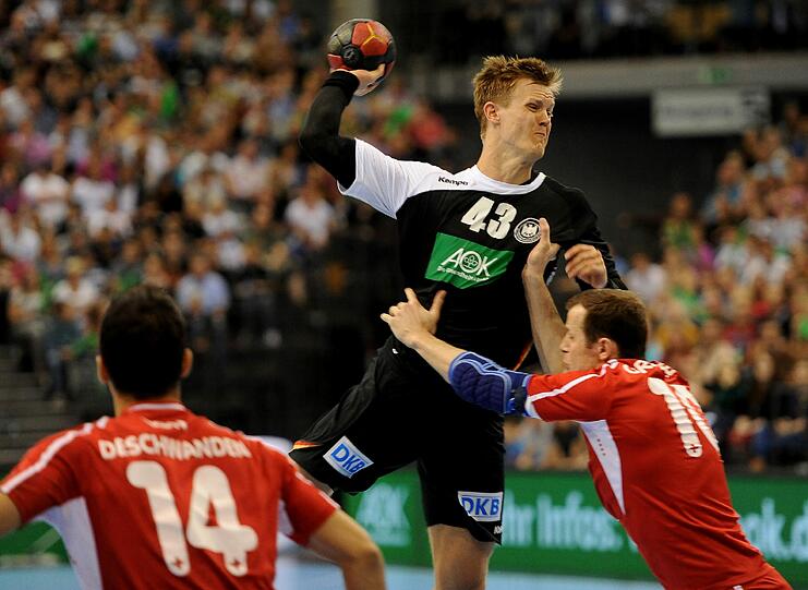 Deutschlands Niclas Pieczkowski (Mitte) wirft gegen den Schweizer David Graubner auf das Tor. Foto: Harald Tittel
