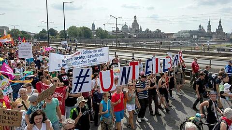 Vor der historischen Altstadtkulisse gehen Tausende Teilnehmer der Demonstration des Bündnisses #Unteilbar über die Carolabrücke in Dresden.