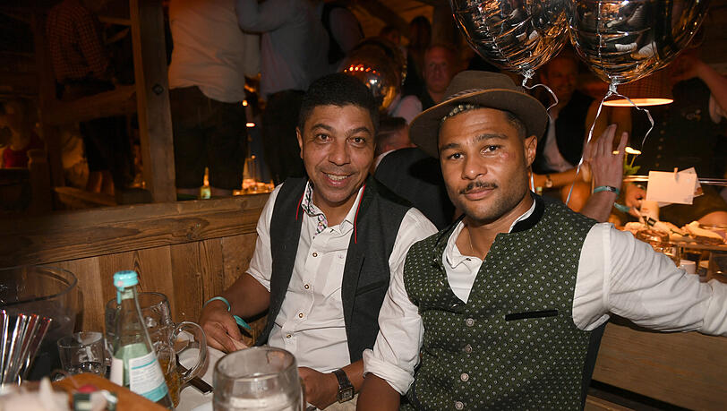 Die Fu&szlig;baller Giovane Elber (l.) und Serge Gnabry feiern beim 25-j&auml;hrigen Jubil&auml;um des "Almauftriebs" im K&auml;fer-Zelt am 17. September 2023.