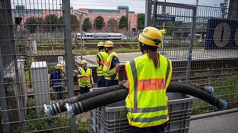 Einsatzkräfte vom THW verlegen Schlauchleitungen auf den S-Bahngleisen in der nähe der Haltestelle Hackerbrücke. Foto: Lino Mirgeler/Archivbild